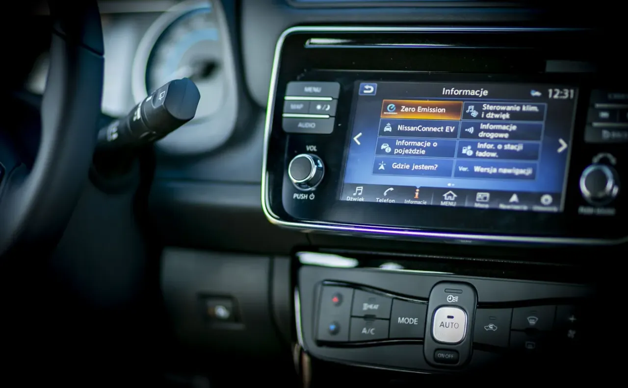 Wnętrze samochodu elektrycznego z ekranem informującym o 