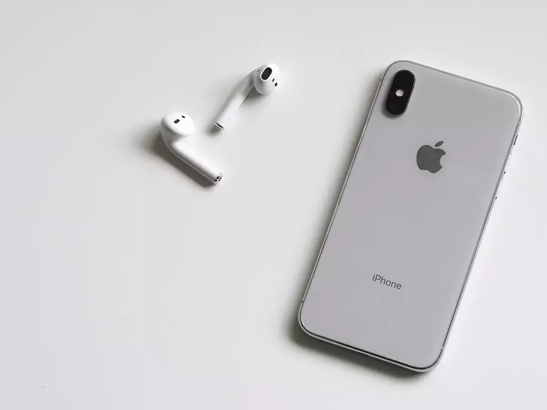 iPhone z ikoną Bluetooth i słuchawki bezprzewodowe