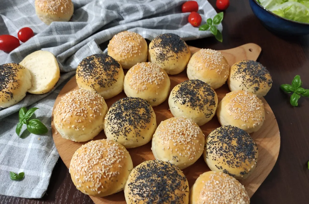 Świeżo upieczone, złociste mini bułeczki do burgerów, posypane sezamem i makiem. Idealne, gdy zastanawiasz się, gdzie kupić mini bułeczki do burgerów.