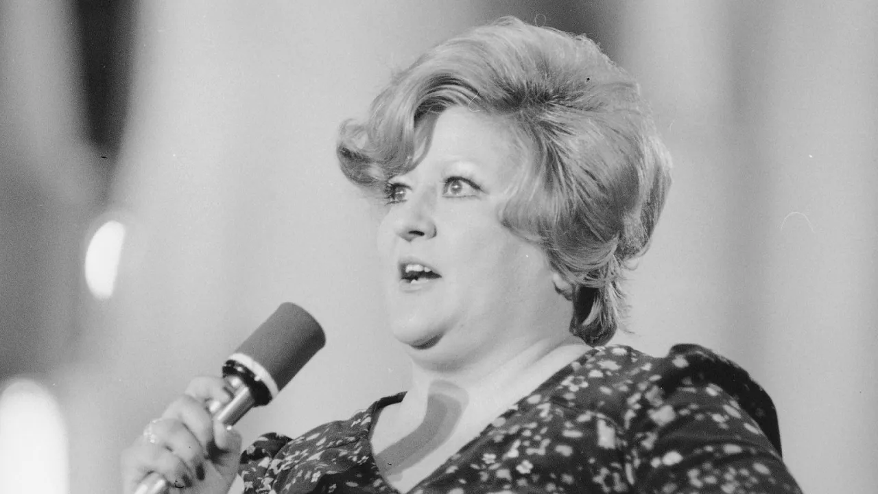 Wokalistka śpiewa, trzymając mikrofon. Może to być fragment występu z piosenką 