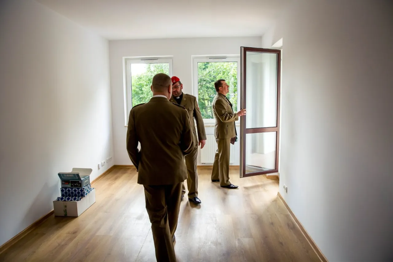 Trzech żołnierzy w mundurach ogląda puste mieszkanie. Czy to nowy dom, czy żołnierz dostaje mieszkanie?