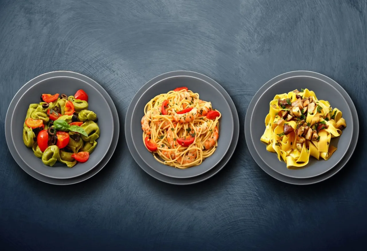 Trzy talerze z makaronem: zielone tortellini z pomidorami i oliwkami, spaghetti z krewetkami i pomidorkami, oraz tagliatelle z grzybami. Idealny makaron bezglutenowy przepis.