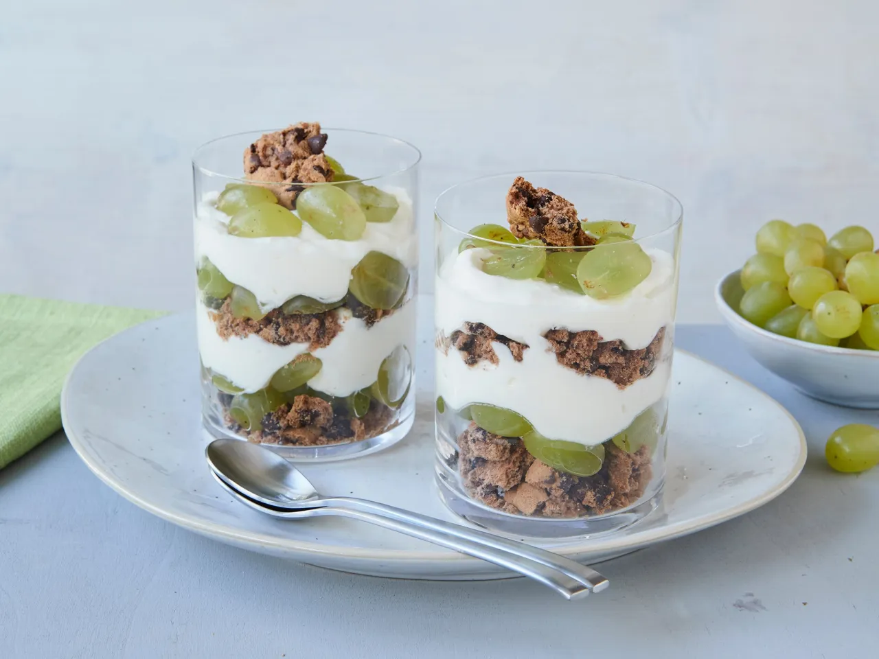 Schichtdessert im Glas mit Trauben und Keksen
