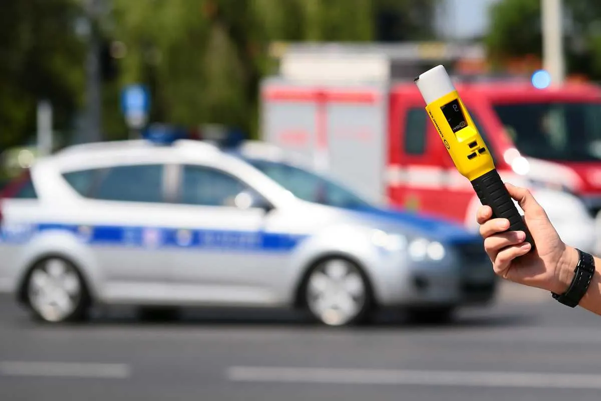 Policjant z alkomatem w drzwiach domu