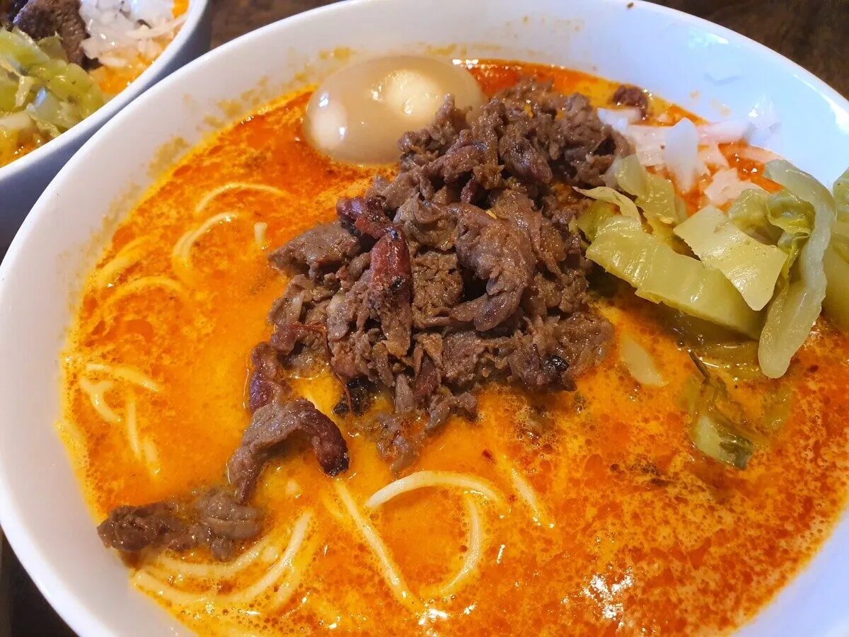 Aksamitny bulion z bbq ramen, z kawałkami soczystej wołowiny, jajkiem i chrupiącą kapustą.