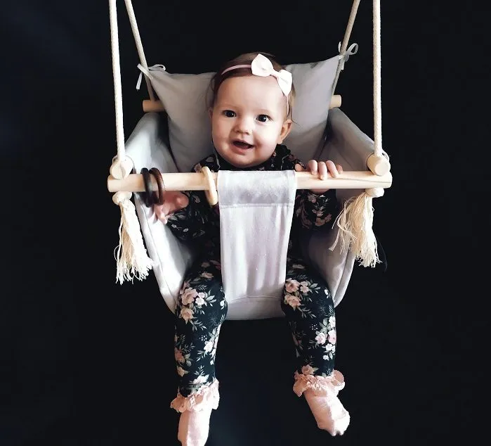 niemowlę w huśtawce z uśmiechem