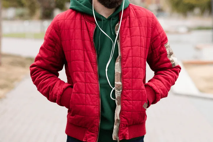 osoba mierząca rękaw kurtki centymetrem krawieckim na stole