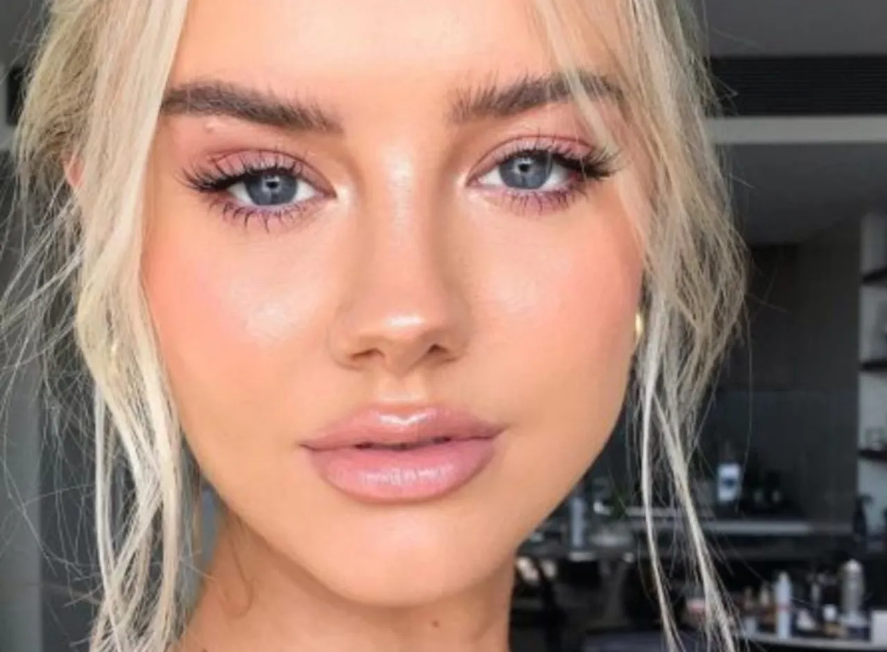 Delikatny makijaż rozświetlający oko, podkreślający błękitne tęczówki. Różowe cienie i długie rzęsy dodają spojrzeniu głębi.