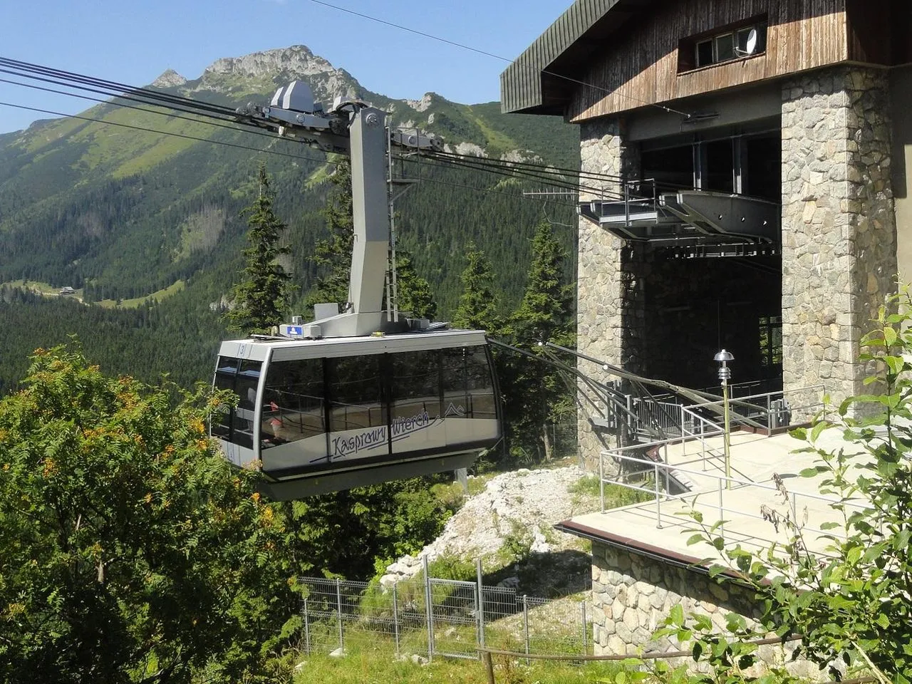 Kasprowy Wierch kolej wjeżdża na stację. W tle góry i lasy.