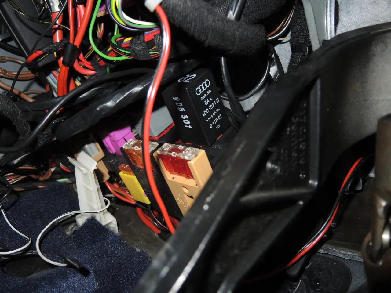 Widok na wiązkę przewodów i bezpieczniki. Gdzie jest sterownik centralnego zamka Audi A4 B5? Prawdopodobnie ukryty wśród kabli, obok przekaźnika 4D0 907 131.
