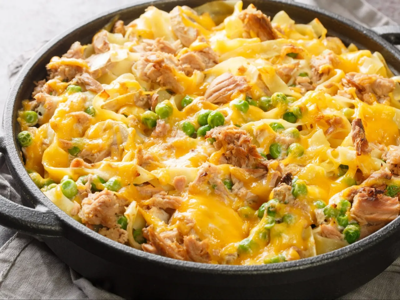 Zapiekanka z makaronem, tuńczykiem i groszkiem, polana ciągnącym się serem. Idealna odpowiedź na pytanie 