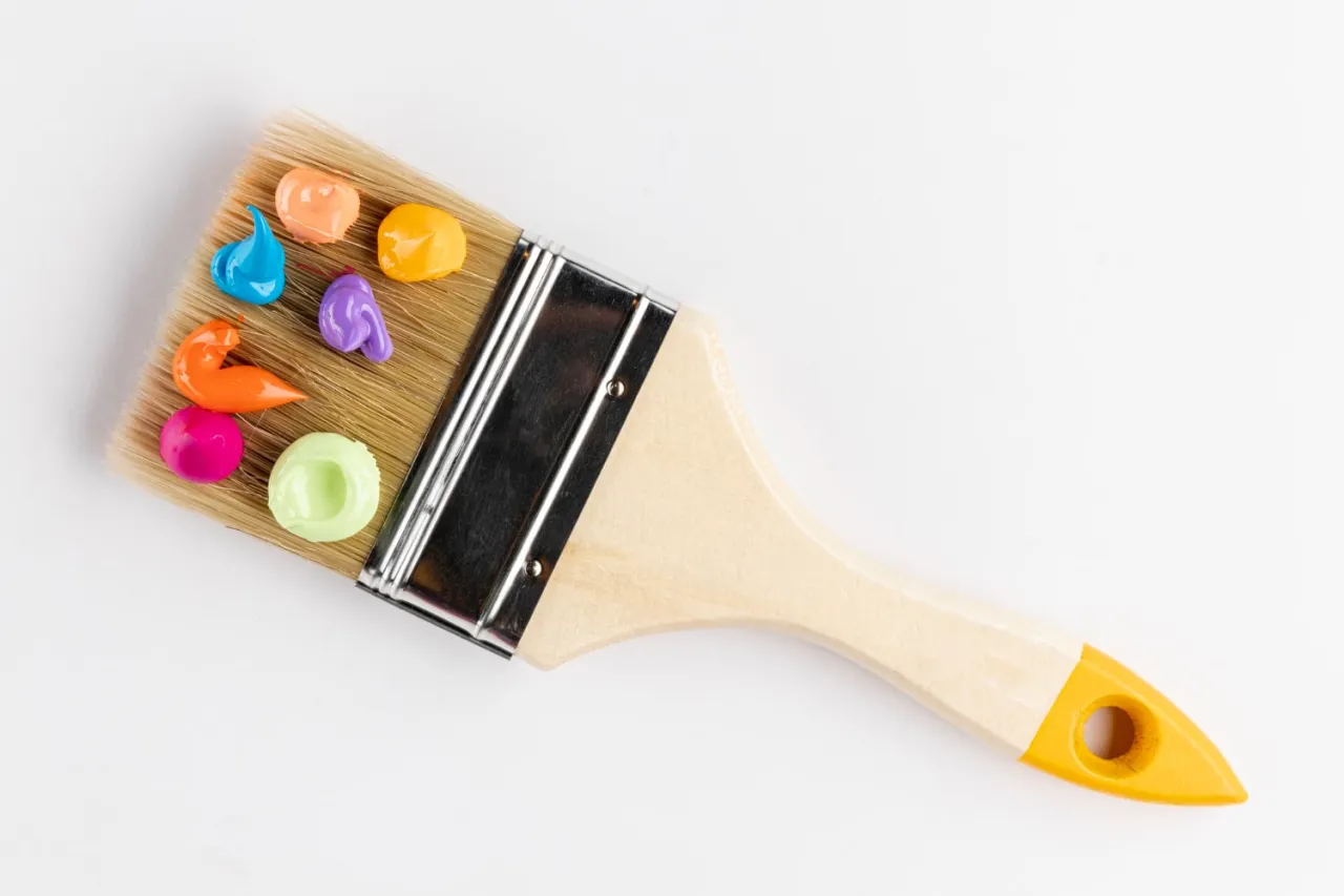 Pędzel z kolorowymi plamkami farby. Zastanawiasz się, jaką farbą pomalować kominek? Wybierz spośród wielu barw!