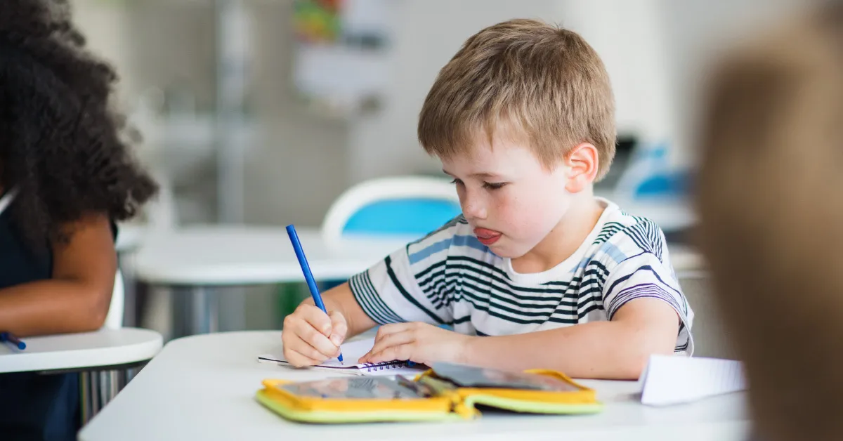 uczeń znudzony na lekcji patrzy przez okno