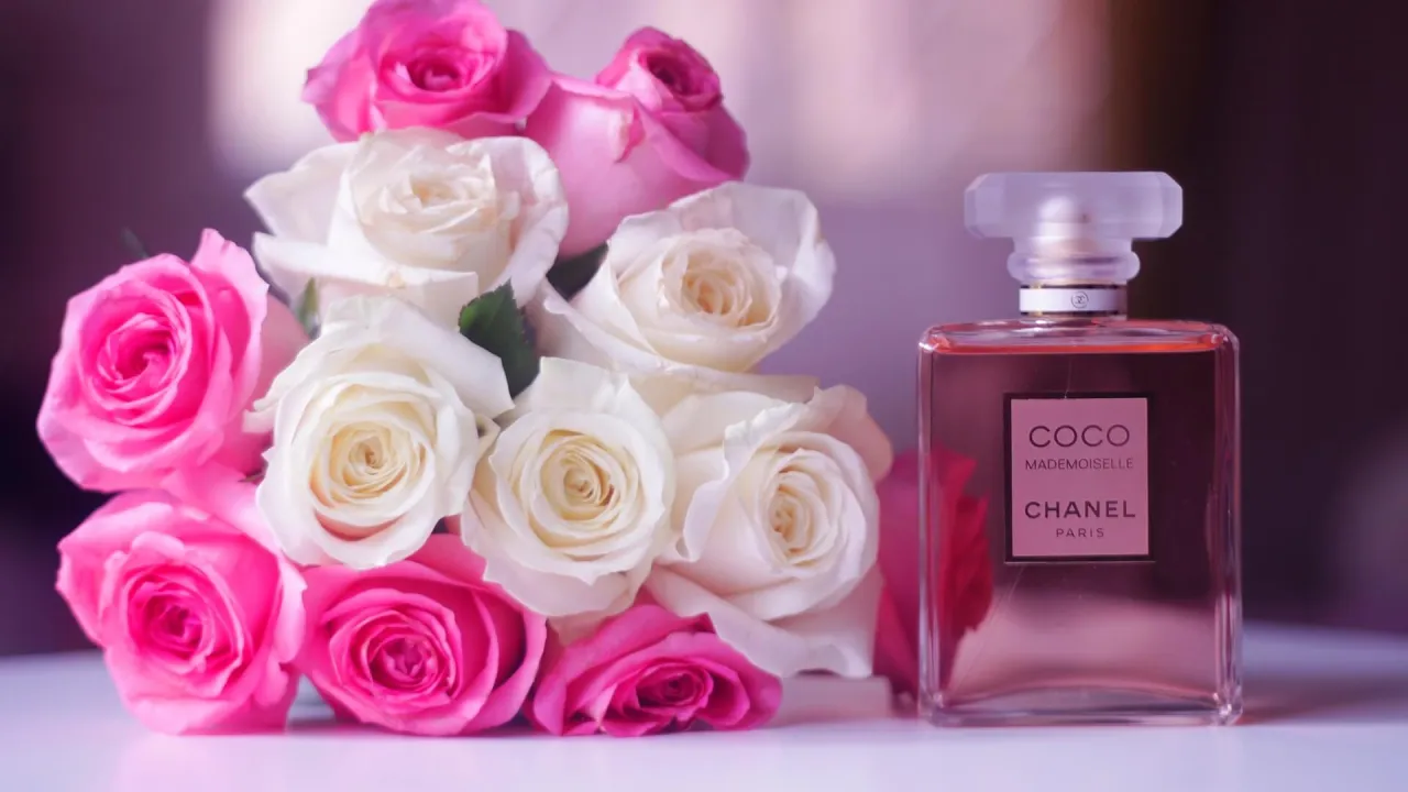 Eleganckie perfumy Chanel Coco Mademoiselle obok bukietu róż. Zastanawiasz się, ile kosztują perfumy tej marki?