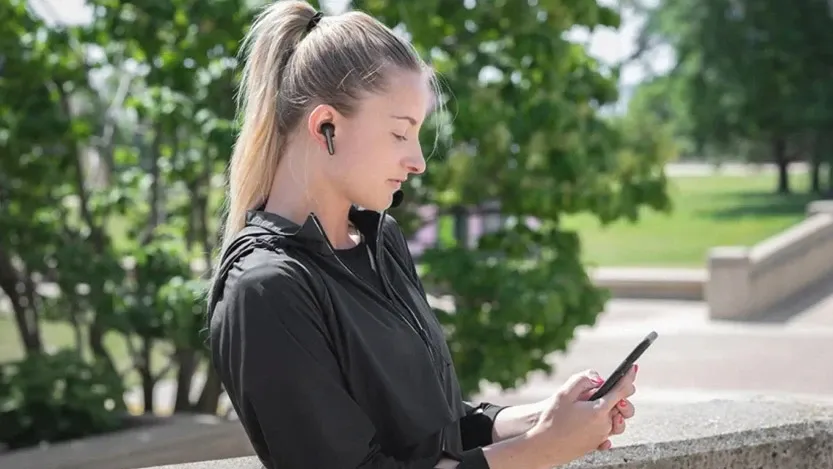 osoba przygotowująca słuchawki bezprzewodowe i telefon do parowania