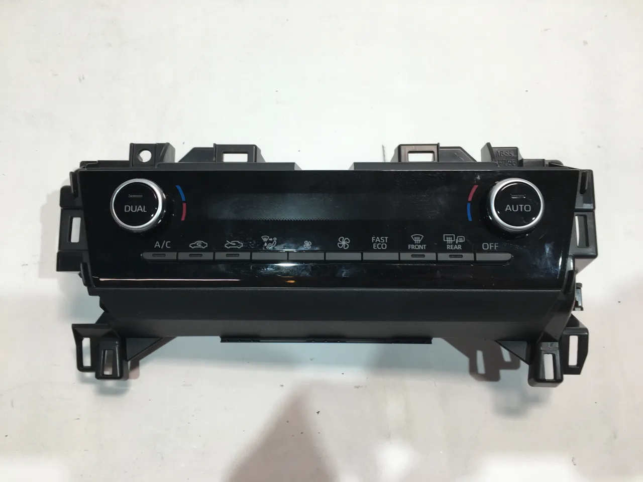 Panel klimatyzacji Toyota Yaris. Jak włączyć chłodzenie? Widoczne przyciski A/C, DUAL, AUTO, FAST, ECO, FRONT, REAR, OFF.