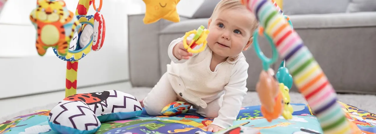 niemowlę na macie edukacyjnej z zabawkami