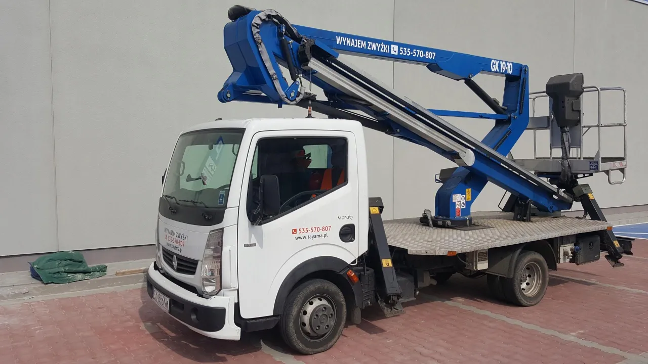 Biała zwyżka z niebieskim wysięgnikiem. Na drzwiach numer telefonu i strona internetowa. Zastanawiasz się, ile kosztuje godzina pracy zwyżki? Zadzwoń i zapytaj!