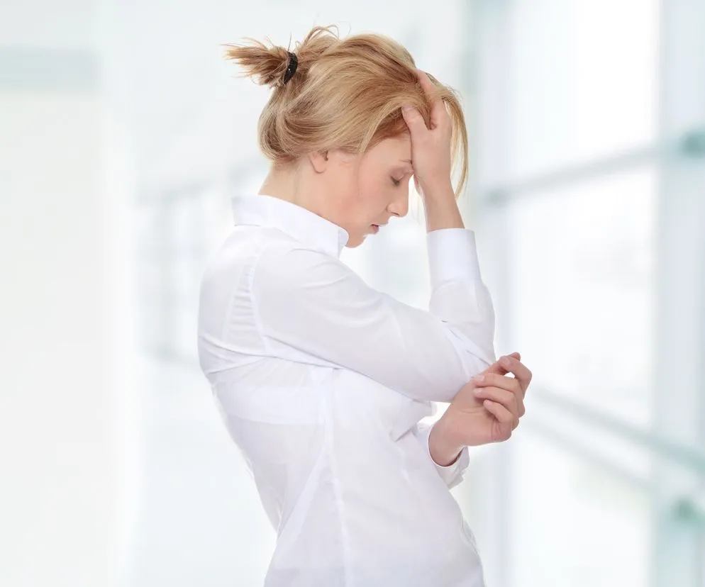 osoba trzymająca się za głowę z bólu jako symbol ukrytego cierpienia