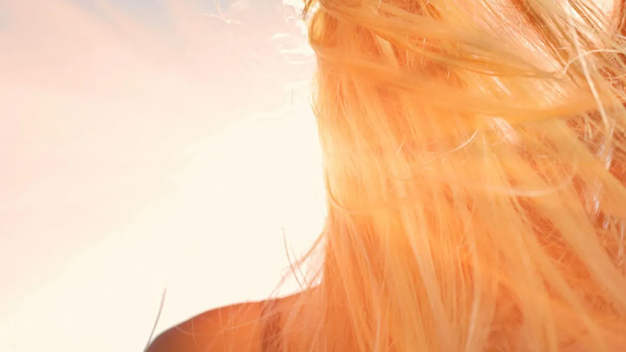 Frau mit goldenen blonden Haaren in der Sonne