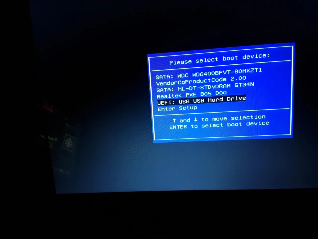 Ekran wyboru urządzenia rozruchowego. Widoczna partycja systemowa EFI, dysk SATA i USB. Wybierz urządzenie do uruchomienia systemu.