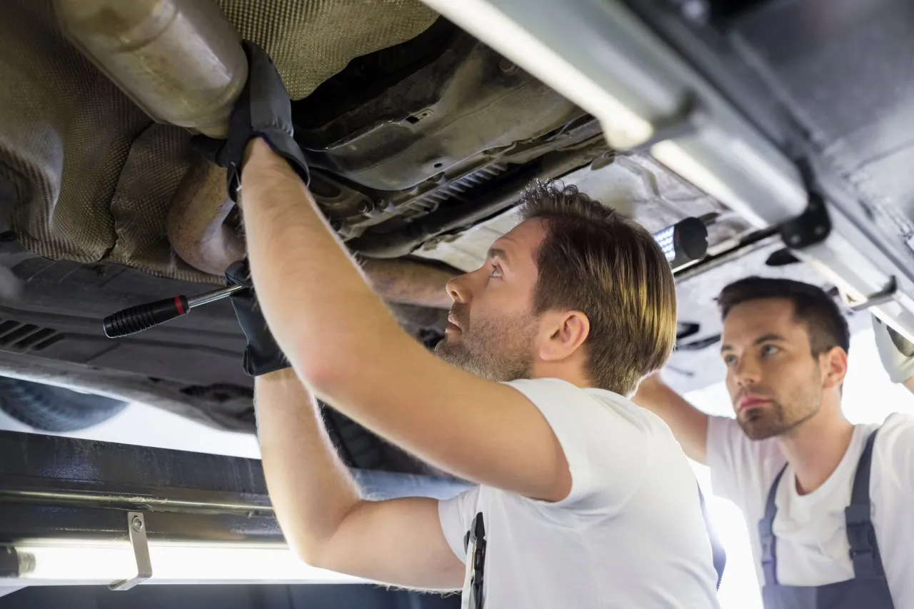 mécanicien remplaçant un filtre à particules dans un garage