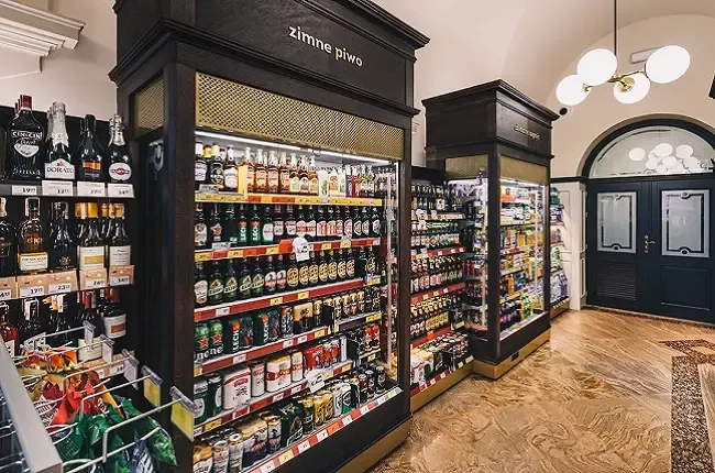 wnętrze nowoczesnego sklepu monopolowego z alkoholem na półkach