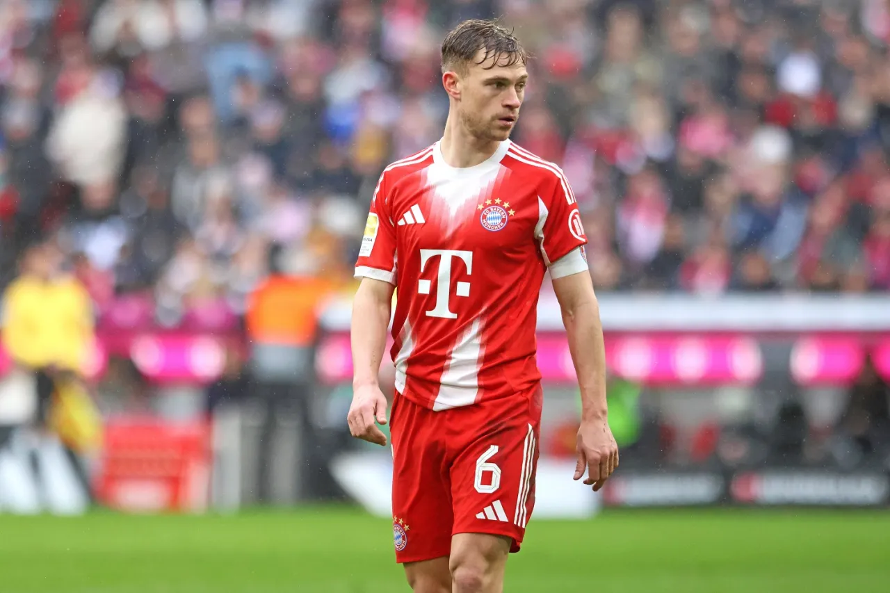 Piłkarz w czerwonej koszulce z numerem 6, kt&oacute;ry podczas meczu przebiega wiele kilometr&oacute;w, stoi na boisku.