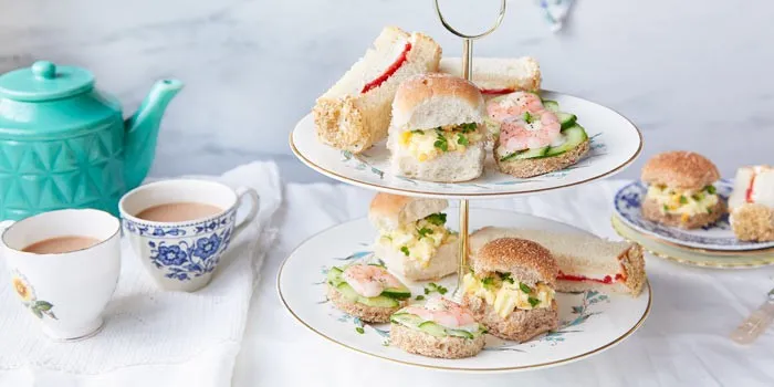 Traditional British afternoon tea setup with scones, sandwiches, and tea