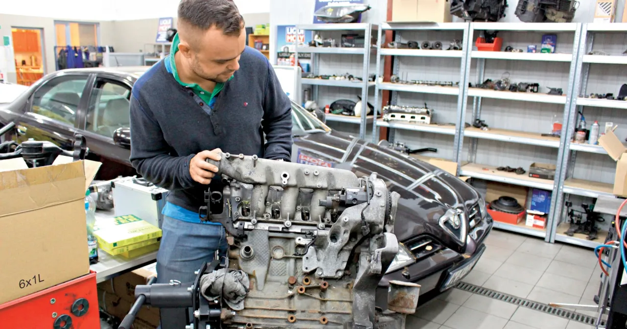 Uszkodzony silnik samochodu, mechanik diagnozujący silnik
