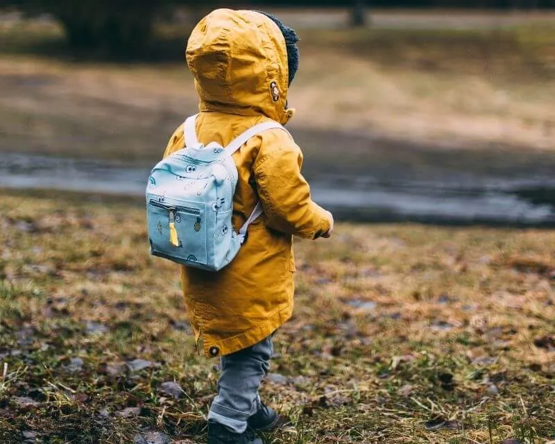 dziecko przymierzające plecak w sklepie stacjonarnym