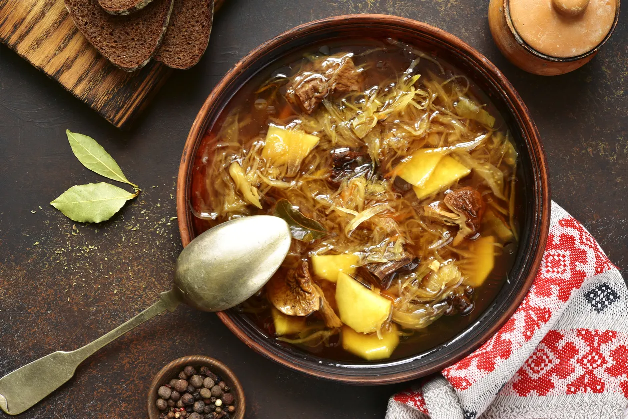 Gęsty kapuśniak ze świeżej kapusty z ziemniakami i mięsem, podany z chlebem. Idealny na chłodne dni, przypomina domową kwaśnicę.