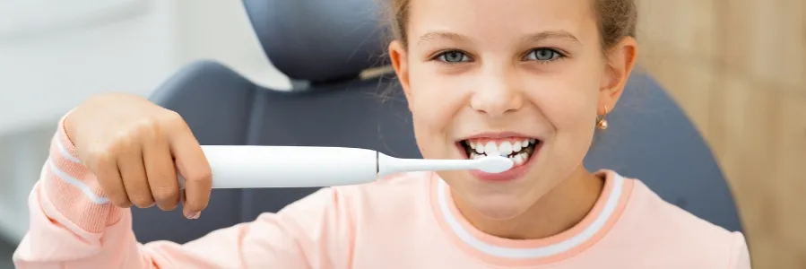 dziecko myjące zęby szczoteczką soniczną