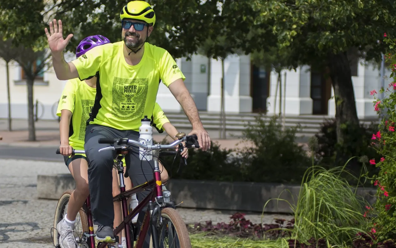 Mężczyzna na rowerze tandem macha ręką, ciesząc się jazdą po trasach rowerowych Białegostoku.