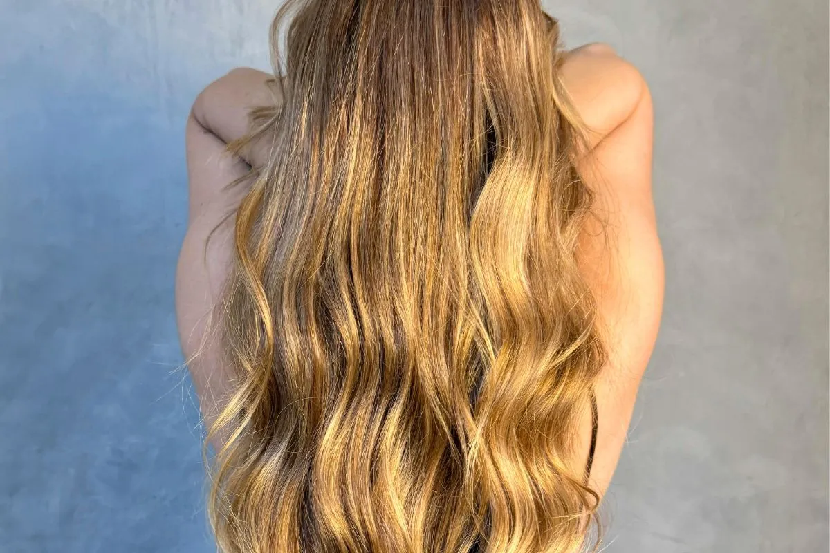 kobieta nakładająca odżywkę na włosy