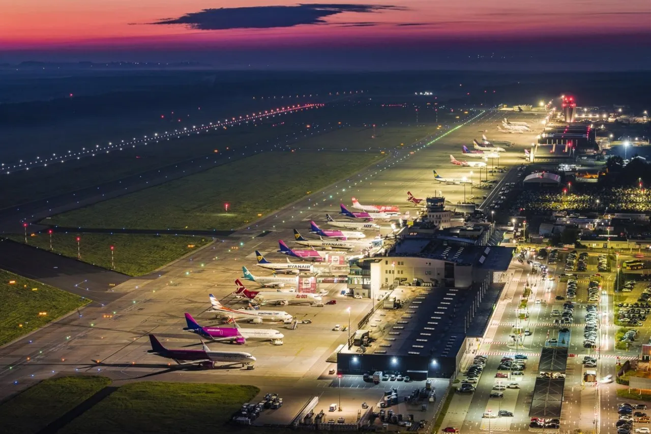 Lotnisko nocą, samoloty czekają na start. Zastanawiasz się, ile się leci na Zanzibar z Polski?