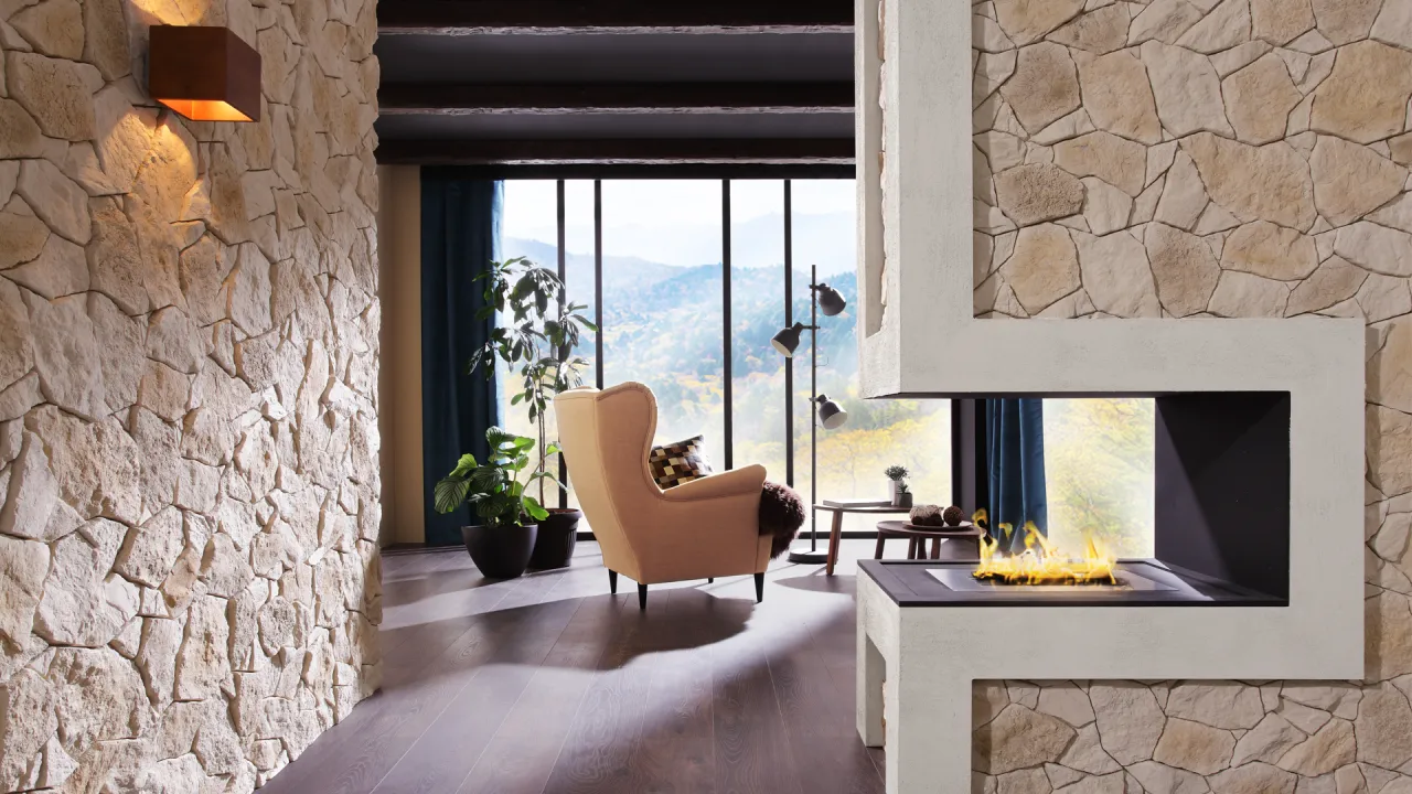 Kamień naturalny to świetny pomysł, czym wykończyć komin wewnątrz. Wnętrze z kamiennym kominkiem i ścianą.