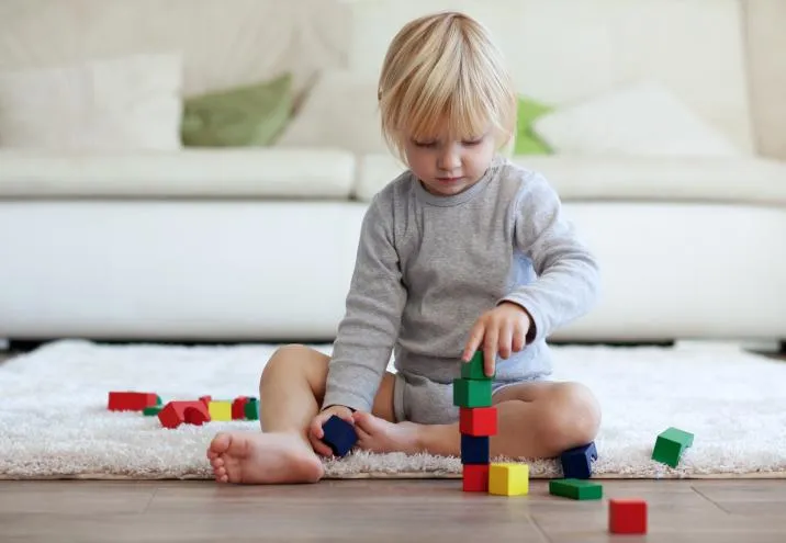 Dziecko samodzielnie bawiące się z uśmiechem