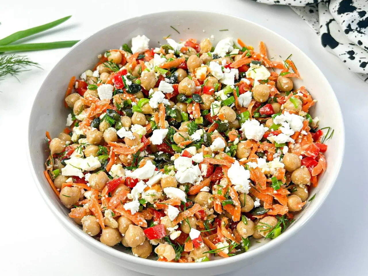 Kolorowa sałatka z ciecierzycy, marchewki, papryki i sera feta. Idealny przepis na zdrową sałatkę pełną smaku i witamin.