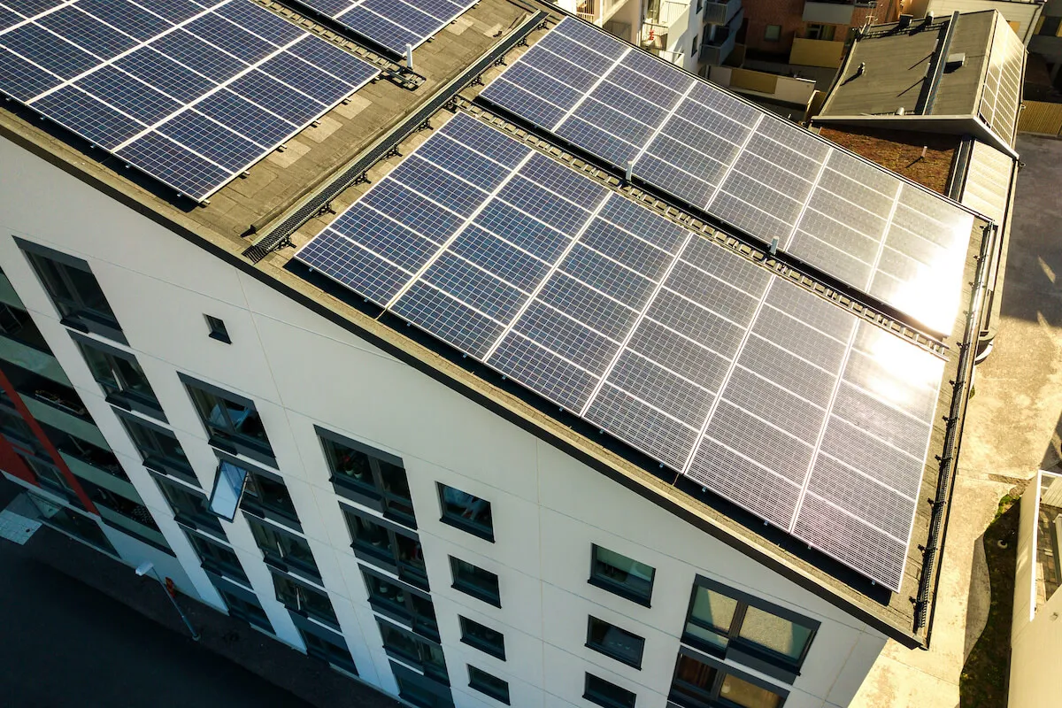 Panele fotowoltaiczne na dachu bloku mieszkalnego