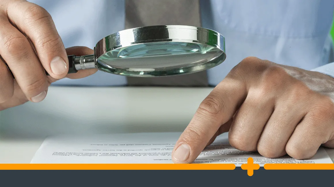 Osoba czytająca umowę pożyczki i lupa