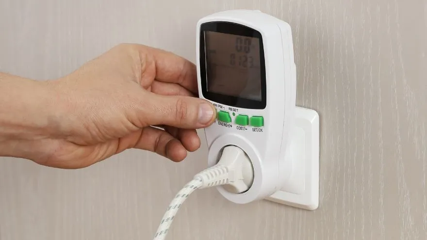 Watomierz podłączony do gniazdka elektrycznego pokazujący zużycie prądu