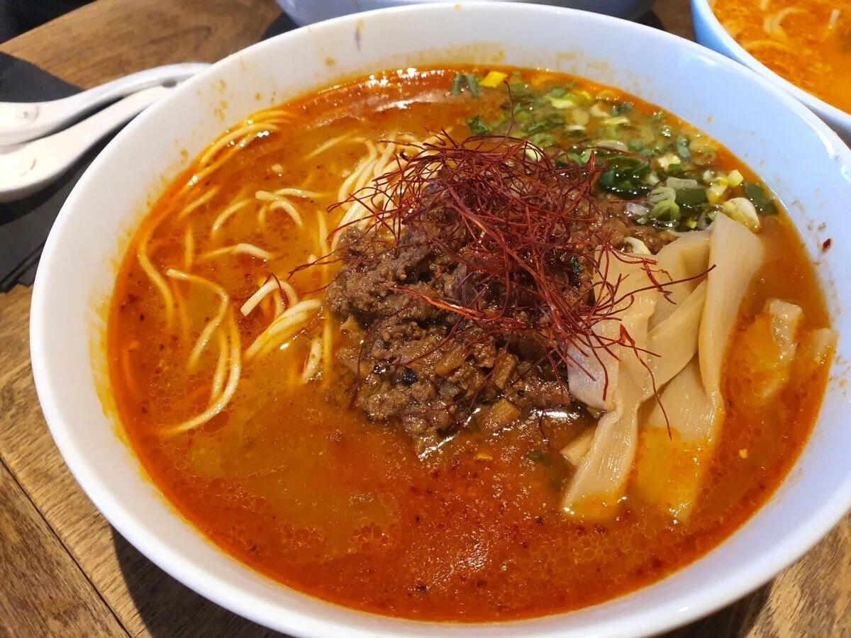 Miseczka aromatycznego ramen z mielonym mięsem, bambusem i chili. Pyszny bbq ramen w gorącym bulionie.