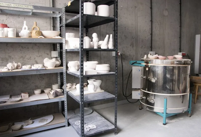 wnętrze pracowni ceramicznej z półkami pełnymi glinianych naczyń