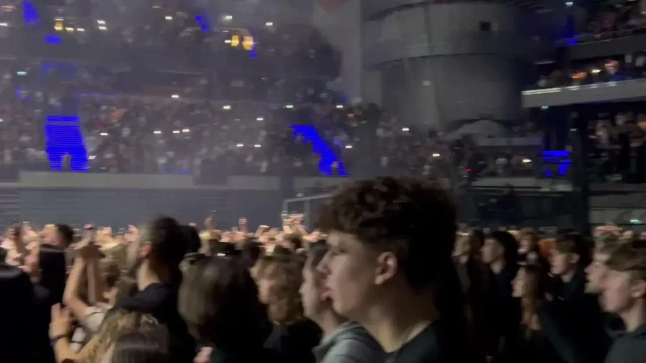 Tłum na koncercie, światła, niebieskie ekrany. Fani zastanawiają się, ile trwają koncerty Maty.