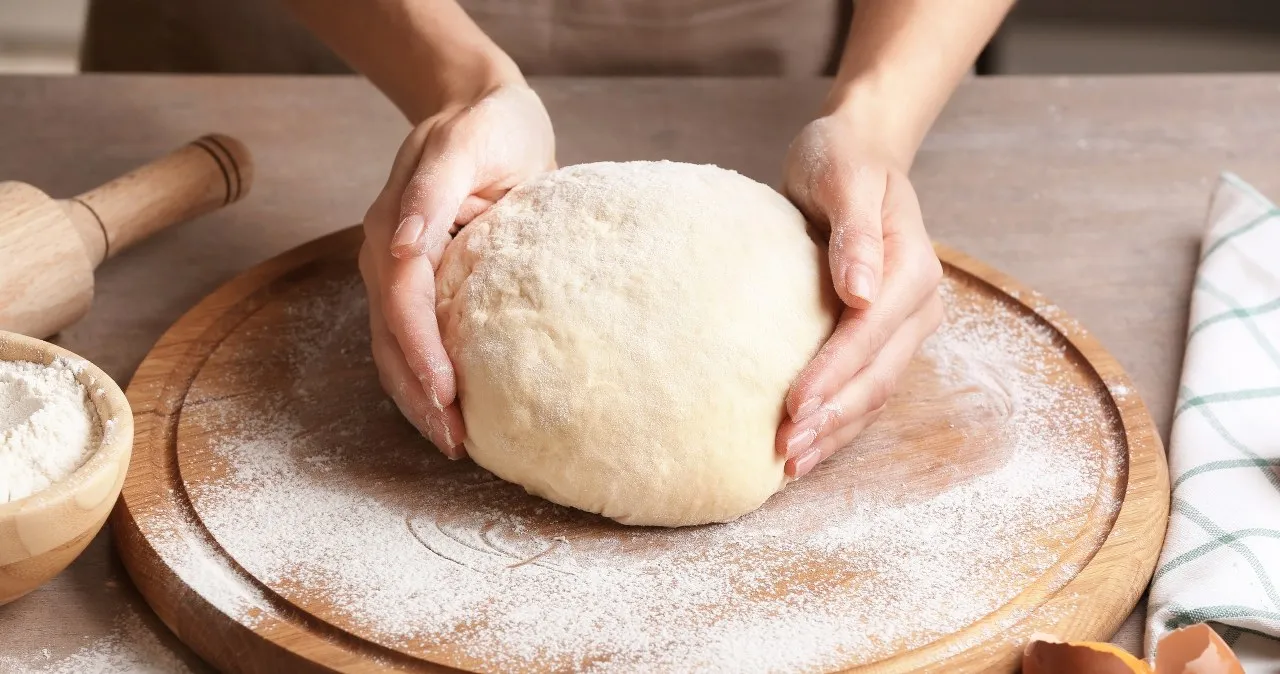 kuchnia z ciastem drożdżowym, ręce wyrabiające ciasto