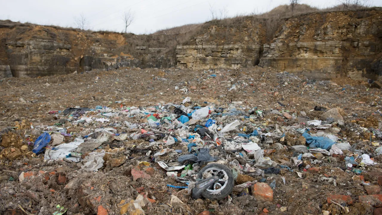 G&oacute;ra śmieci na wysypisku, z widocznym kołem od hulajnogi. Zastanawiasz się, ile kosztuje tona śmieci na wysypisku?