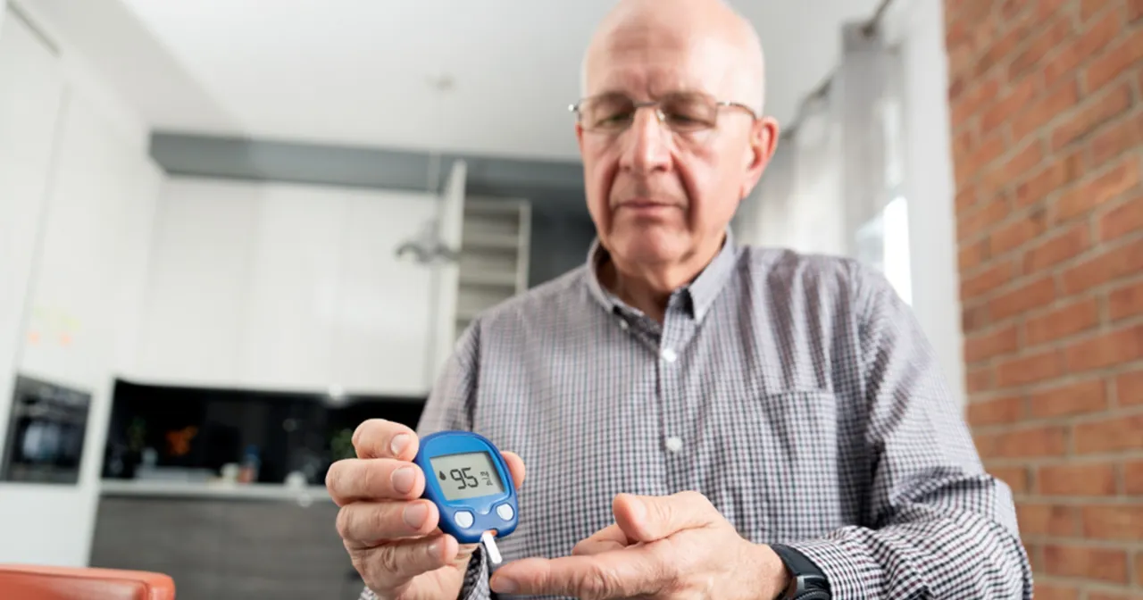 senior mierzący cukier glukometrem