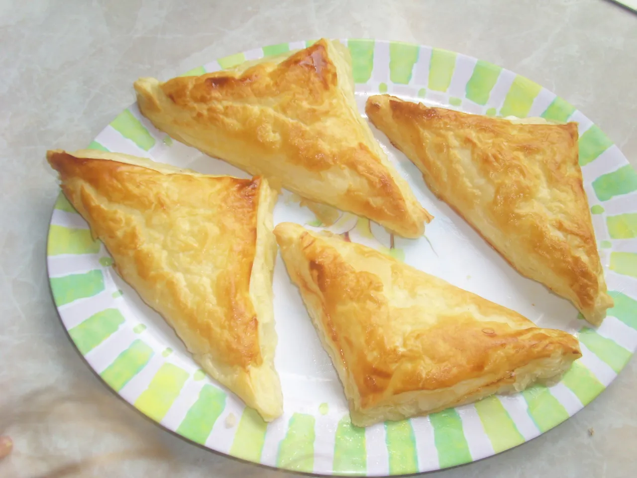 ciastka twarogowe tr&oacute;jkąty z cukrem na talerzu