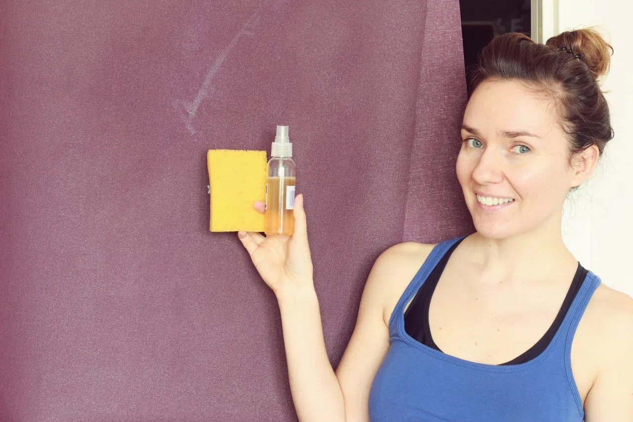 osoba czyszcząca matę do ćwiczeń